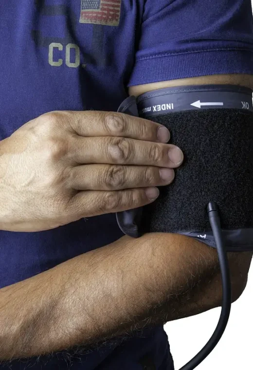 zoomed in image of an international healthcare assistant using a sphygmomanometer on themself