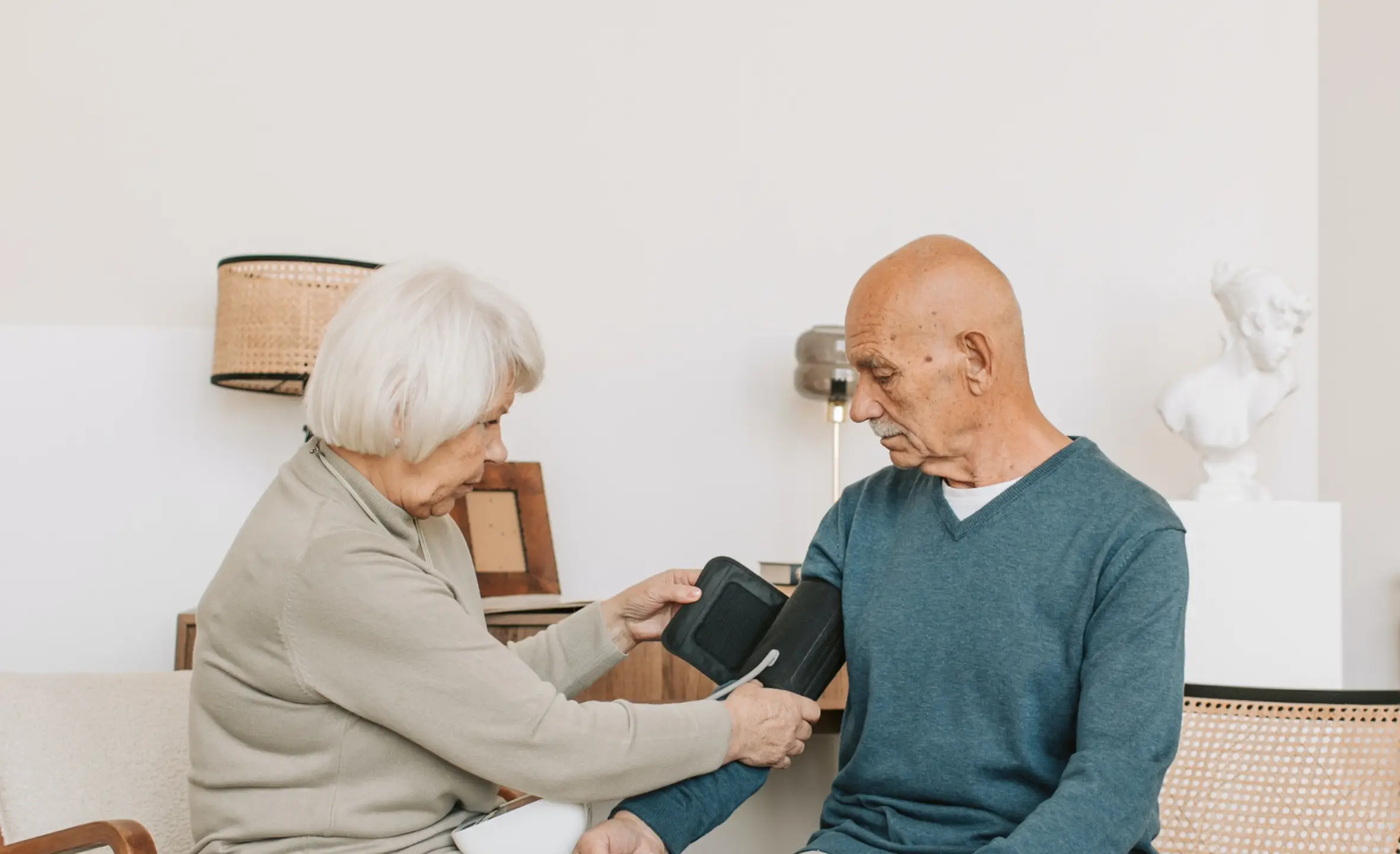 an image of an elderly woman checking the blood pressure of a man