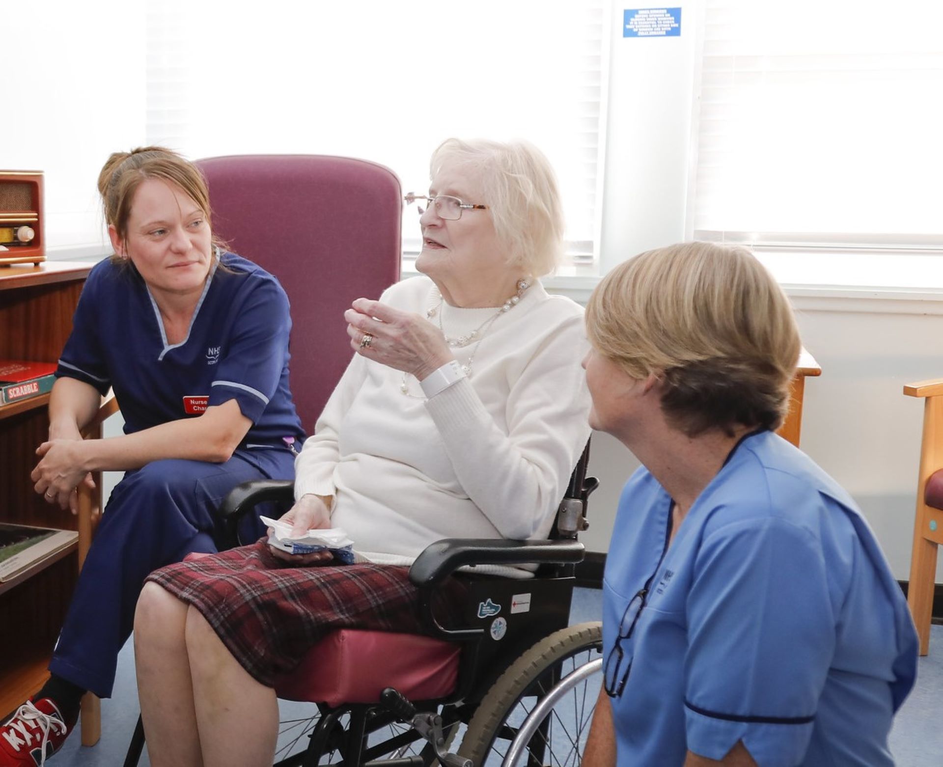 care staff provided by a care staffing agency with an elderly resident in a care home talking