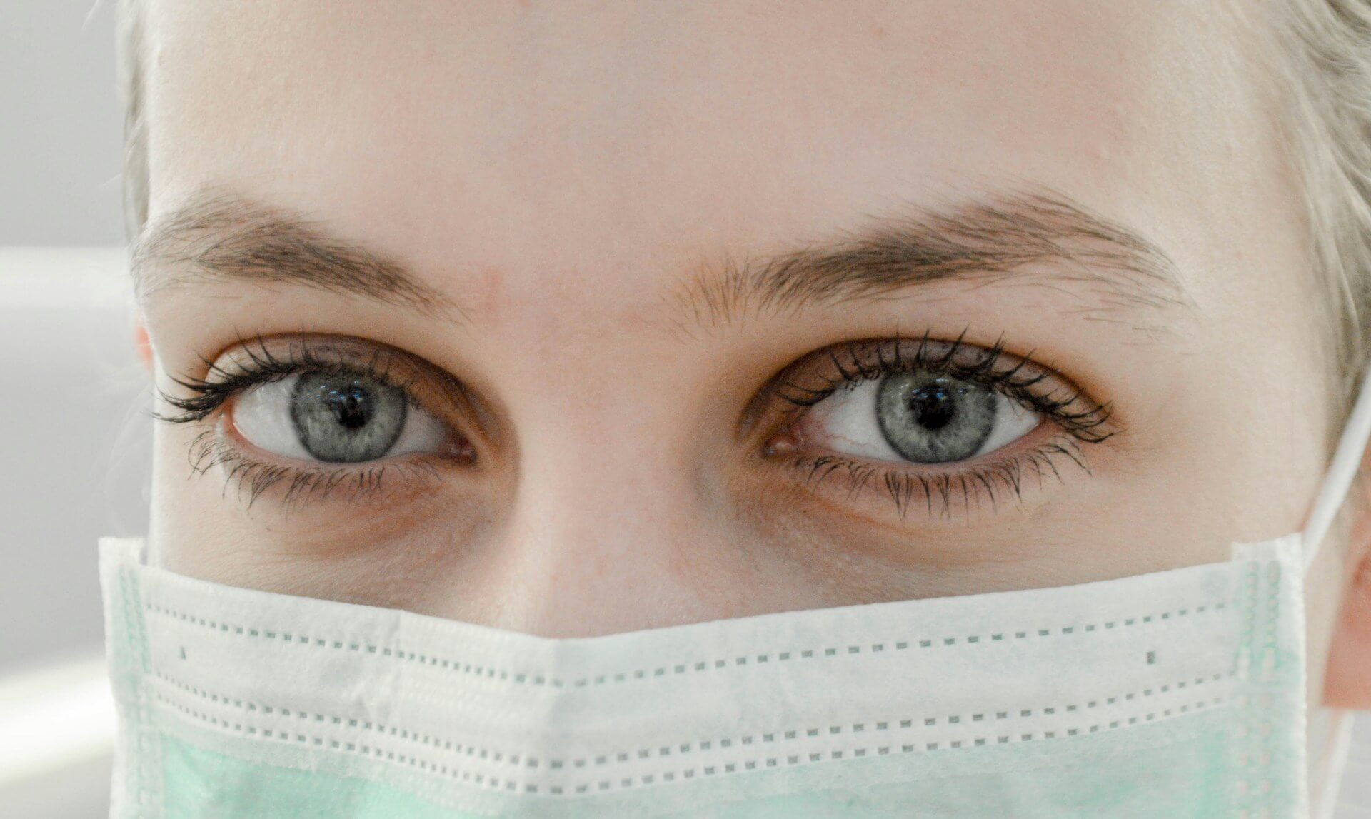 close up images of a nurses' eyes wearing a PPE mask